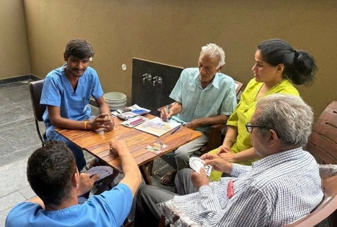 Residents enjoying a card game with a caregiver at Vintage Care Home - 1